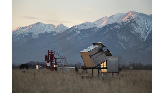 A HiSCORE station with its electronics box in the foreground and an IACT under construction in the background, located in the Tunka valley in Siberia. Credit: Taiga Collaboration.